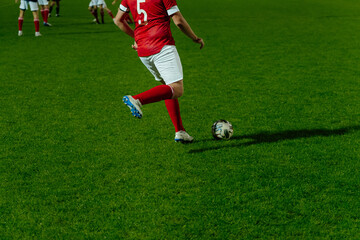 football player hits ball during football match