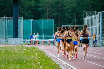 group female athletes run middle distance race