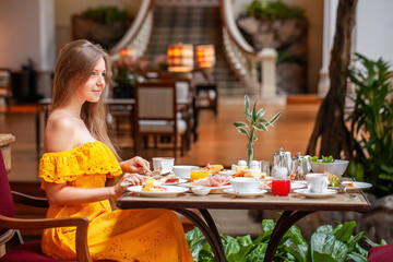 Woman Enjoying breakfast meal in Luxury Restaurant in modern resort or hotel