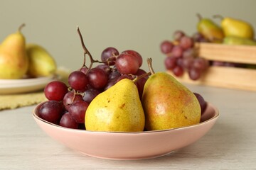 Naklejka na ściany i meble Fresh ripe grapes and pears on white wooden table