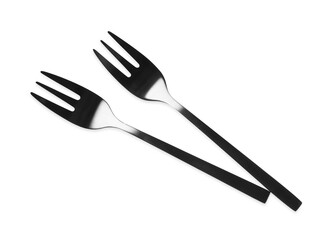 New black dessert forks on white background, top view