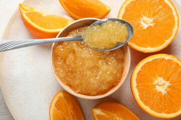 Bowl of delicious orange jam and fresh fruits on white table, top view