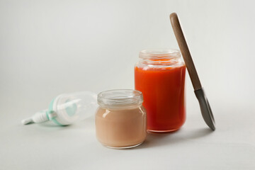 Healthy baby food, spoon and nibbler on white background