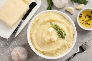 Delicious mashed potato with dill and butter served on light grey table, flat lay