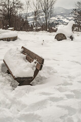 La panchina sotto la neve nel giardino di montagna