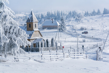 Church Winter fairytale landscape in the Carpathian mountains village, Transylvania Romania