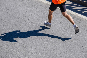 legs male running race. silhouette runner on asphalt
