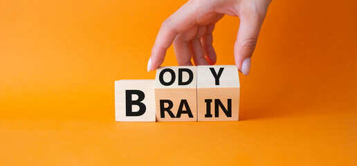 Body vs Brain symbol. Businessman hand turns wooden cubes and changes word Brain to Body. Beautiful...