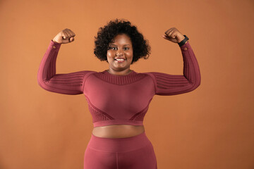 black curvy girl body positive wearing sportswear showing muscles feminist person