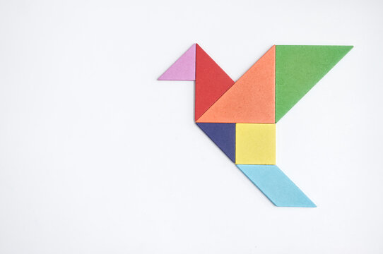 color tangram puzzle in flying bird shape on white background