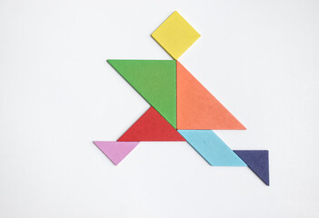 Color tangram puzzle in running man shape on white background