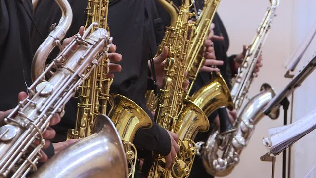 Jazz musicians play the saxophone, close-up