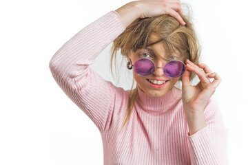Cheerful woman in sunglasses touching, messing up hair with hands on a white background. High...