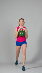 Training with kettlebells, a young athlete performs exercises with kettlebells, kettlebell lifting for the tone of the whole body