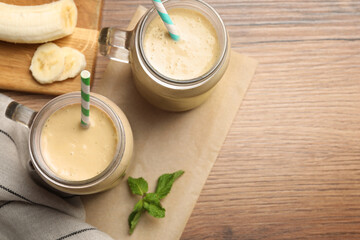 Tasty banana smoothie and mint on wooden table, flay lay. Space for text