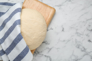 Fresh yeast dough on white marble table, top view. Space for text
