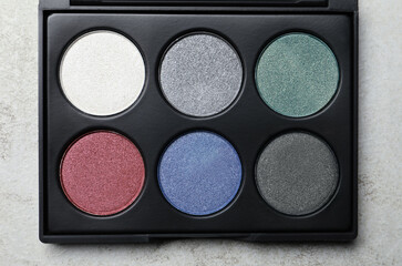 Beautiful eye shadow palette on grey table, top view