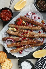 Tasty grilled sausages served on light table, flat lay