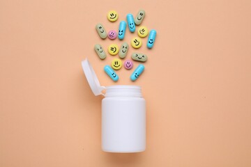 Bottle and antidepressant pills with funny faces on pale orange background, flat lay