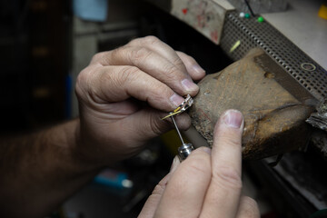 Un artigiano realizza a mano un anello in oro.