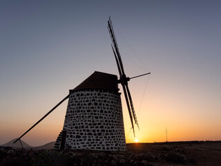 An old windmill on the island of Fuerteventura (Canary Islands, Spain) during a beautiful sunset.