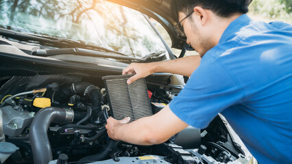 Young man checking and maintenance air filter on his car. Car repair and maintenanc concept.