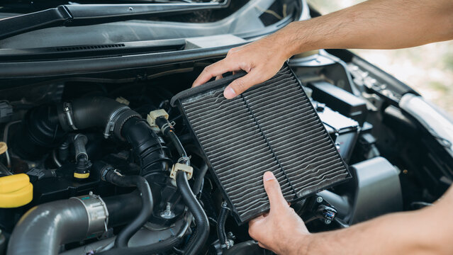 Young man checking and maintenance air filter on his car. Car repair and maintenanc concept.