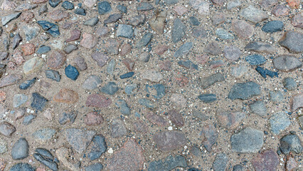 Old stone road of stones of different sizes and colors as a natural background
