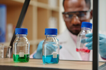 Small bottles with colorful reagents on shelf in laboratory