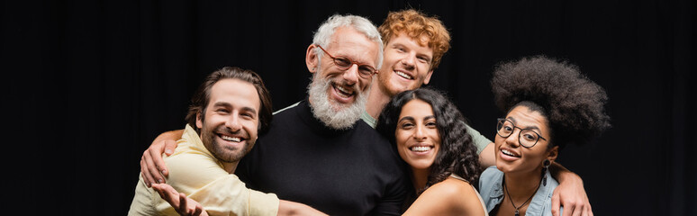 happy multicultural troupe embracing mature teacher of acting skills and smiling at camera, banner.