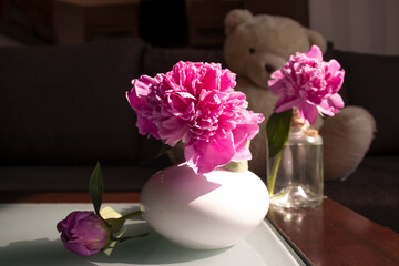 Vase with a bouquet of peony in the room