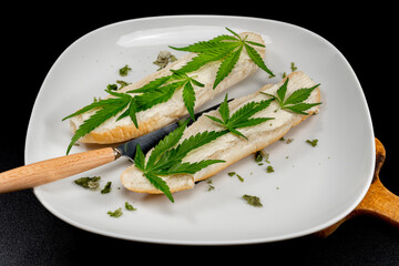 White plate with butter buns decorated green marijuana Matanuska variety leafs