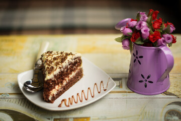 PLATO CON REBANADA DE DELICIOSA TORTA DE CHOCOLATE CASERO EN UNA MESA COLORIDA