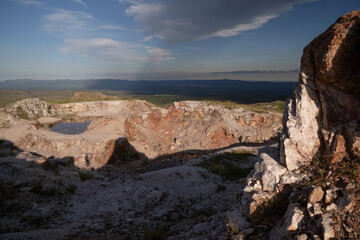 Fototapeta na wymiar Quartz open cast mine at sunset. View of the white quartz hills with beautiful dusk color