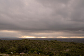 Dramatic cloudscape. Panorama view of the hills and field under a cloudy sky, at dusk. 