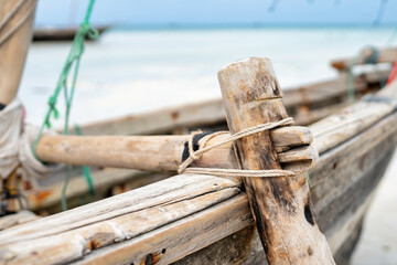 Wooden boat anchored on the African shore Zanzibar in clear ocean water