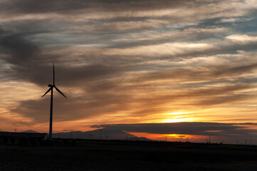 A modern aerogenerator (windmill) during a beautiful sunset.