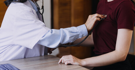 Homecare nursing service and elderly people cardiology healthcare. Close up of young hispanic female doctor nurse check mature caucasian man patient heartbeat using stethoscope during visit
