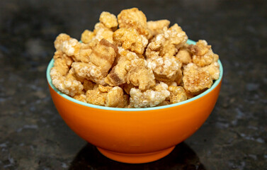 Traditional crackling on dark surface in selective focus. Brazilian food