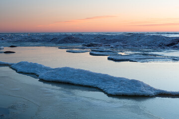 Wonderfully beautiful sunset by the sea in winter with ice