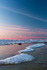 Wonderfully beautiful sunset by the sea in winter with ice