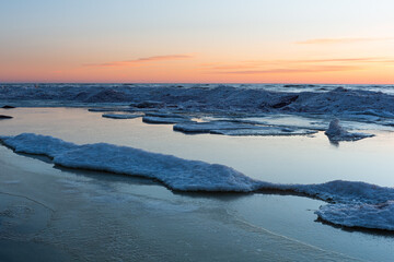 Wonderfully beautiful sunset by the sea in winter with ice
