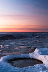 Wonderfully beautiful sunset by the sea in winter with ice