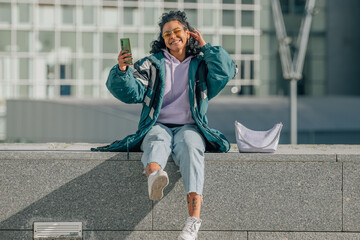 girl with mobile phone in the street smiling