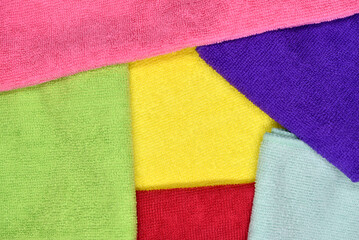 Multicolored towels laid on top of each other. Colored terry towels. Background of multicolored rags.