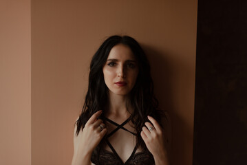 Sexy young brunette girl in black lingerie in loft photo studio