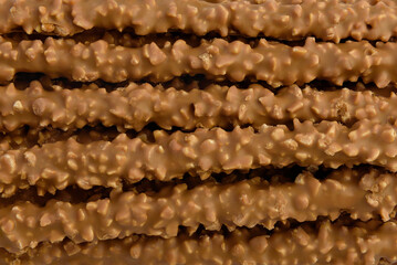 Cracker pretzel sticks toffee-cream glazing and peanuts isolated on white background.
