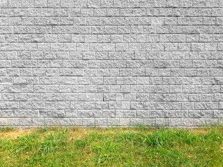 White brick wall texture background with grass.