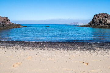 Stunning view of exotic colors on Lanzarote, Canary Islands, Spain, Europe. Turquoise color of the sea and crystalline sea. Black rocks and fine sands. Papagayo Beach (Playa de Papagayo).