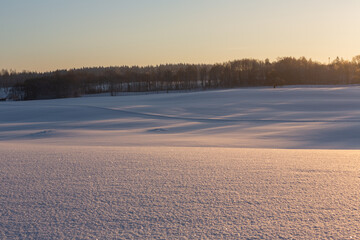 sunny, snowy winter day in the countryside at sunset